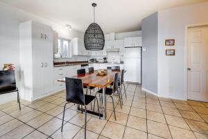 a kitchen with white cabinets and a wooden table and chairs at 2CH - Fireplace Panoramic View - Upper Unit in Petite-Rivière-Saint-François