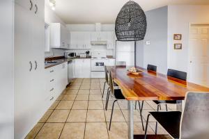 a kitchen with a wooden table and chairs at 2CH - Fireplace Panoramic View - Upper Unit in Petite-Rivière-Saint-François +27 photos