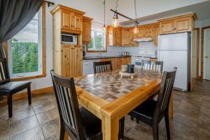 a kitchen with a wooden table and chairs at Panoramic View 2BR FP BBQ Terrace - Upper in Petite-Rivière-Saint-François +27 photos