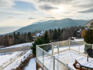 a snow covered balcony with a view of a mountain at Panoramic View 2BR FP BBQ Terrace - Upper in Petite-Rivière-Saint-François