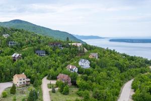 an aerial view of a house on a hill near the water at Panoramic View 2BR FP BBQ Terrace - Upper in Petite-Rivière-Saint-François