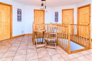 a room with a staircase and a table and a chair at Charlevoix 4BR Cottage Hot Tub & Game Room 12 in Petite-Rivière-Saint-François +24 photos