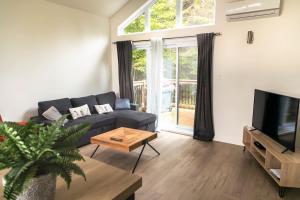 a living room with a couch and a tv at 2CH Relaxation Spa Sauna BBQ Wi-Fi in Pont-Rouge