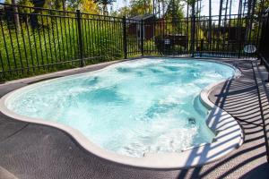 a swimming pool with a chair in it at 2CH Relaxation Spa Sauna BBQ Wi-Fi in Pont-Rouge