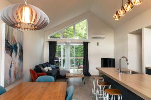 a kitchen and living room with a large window at 2CH Relaxation Spa Sauna BBQ Wi-Fi in Pont-Rouge