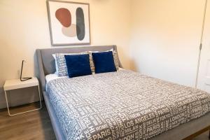 a bedroom with a bed with blue and white sheets at 2CH Relaxation Spa Sauna BBQ Wi-Fi in Pont-Rouge