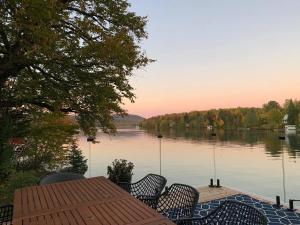a table and chairs with a view of a lake at Lakefront Chalet Hot Tub & Fire Pit Sleeps 6 in Saint-Raymond