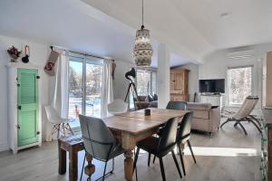 a living room with a dining room table and chairs at Lakefront Chalet Hot Tub & Fire Pit Sleeps 6 in Saint-Raymond +32 photos