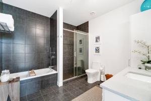 a bathroom with a tub and a toilet and a sink at 3CHParkingGymRooftop97 Walkscore10mins QC in Quebec City