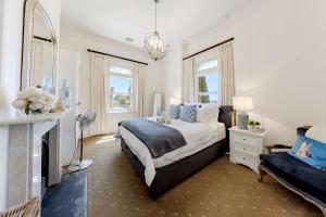 a bedroom with a large bed and a fireplace at QPO Queenscliff in Queenscliff