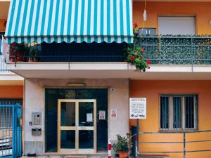 a building with a green and white awning and a door at Sanremo Apartments - Ortensia in Sanremo