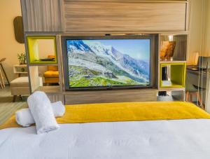 a bedroom with a large tv and a bed at Espectacular Central Loft in Bogotá +38 photos