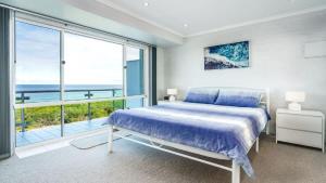 a bedroom with a bed and a large window at Quarterdeck 6 in Tura Beach