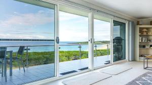 a living room with sliding glass doors and a view of the ocean at Quarterdeck 6 in Tura Beach
