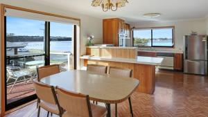 a kitchen with a table and chairs and a large window at SeaLeka 6 in Merimbula