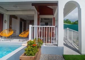 a house with a swimming pool and a porch at Villa piscine privée Grand-Bourg proche plage in Grand-Bourg