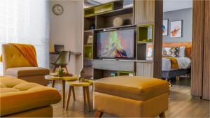 a living room with a tv and a bedroom at Espectacular Central Loft in Bogotá