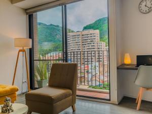 a room with a chair and a large window at Espectacular Central Loft in Bogotá