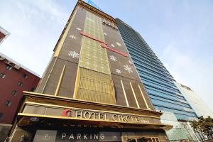 ein Hotelgebäude vor einem hohen Gebäude in der Unterkunft Hapjeong Circle Hotel in Seoul