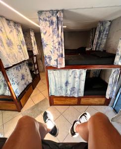 a person laying on the floor in a room with bunk beds at Chamos Hostel Cultural in Arraial do Cabo