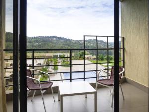a balcony with chairs and a table and a view at Mantis Kivu Marina Bay Hotel in Muhari