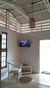 a white room with a table and a tv on the wall at El Carao in Talamanca