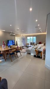 a large living room with a table and a couch at Lara Country House in Guarulhos