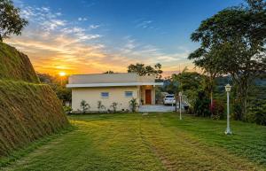 a house with the sunset in the background at Lara Country House in Guarulhos