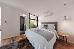 a bedroom with a large bed and a window at Stella on Stevens in Queenscliff +14 photos