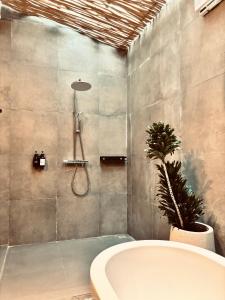 a bathroom with a bath tub and a plant at Home Dejavu in Gili Trawangan +36 photos