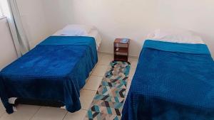 a room with two beds and a night stand at Apto 5 pessoas - Prox FIP e Stop Shop in Brusque