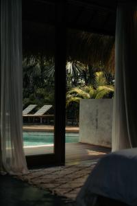 a room with a view of a pool through a window at RONJA Boutique Hotel - Adults Only in Uluwatu +36 photos