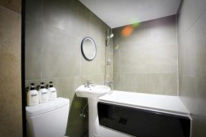 a bathroom with a sink and a toilet and a mirror at Chuncheon Urbane Hotel in Chuncheon