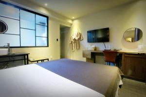 a bedroom with a large bed and a desk and a television at Chuncheon Urbane Hotel in Chuncheon