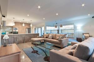 a living room with two couches and a kitchen at Taworri in Queenscliff
