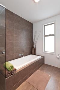 a bath tub in a bathroom with a window at Taworri in Queenscliff