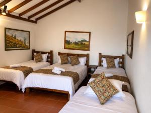 a room with four beds in a room at Yeshca Hotel Boutique in Villa de Leyva