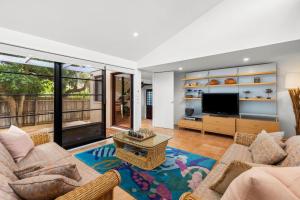 a living room with a couch and a television at The Beach House in Point Lonsdale