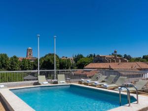 a swimming pool with chaise lounge chairs and a swimming pool at Mercure Arles Centre Arenes in Arles