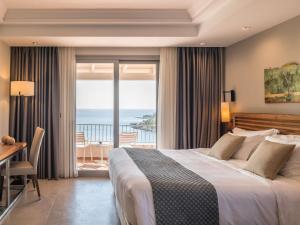 a bedroom with a bed and a view of the ocean at Movenpick Resort Agios Nikolaos Sivota in Syvota +234 photos