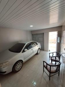 a car parked in a garage with a table and a chair at Conexão Cariri in Juazeiro do Norte