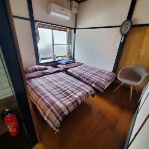 a small room with two beds and a window at 灯りの宿 in Kitakyushu