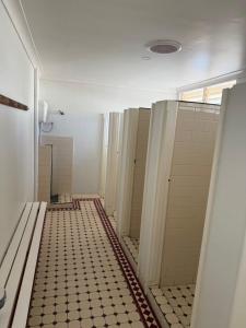 a hallway of a bathroom with a tile floor at Rec Toodyay Hotel in Toodyay +13 photos