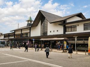 a large building with people walking in the street at The Little Kamakura Hotel 鎌倉駅徒歩2分 in Kamakura