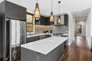 a kitchen with a white counter top and a refrigerator at The Scoop in Queenscliff