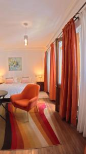 a bedroom with a bed and a chair and a rug at Hostal Boutique Casa La Barca in Santiago