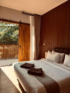 a bedroom with a large bed and a balcony at Home Dejavu in Gili Trawangan
