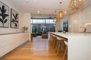 a kitchen with a bar and a living room at Margaret House | Elegant City-Fringe Escape in North Adelaide