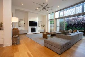 a living room with a couch and a tv at Margaret House | Elegant City-Fringe Escape in North Adelaide