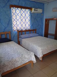 a room with two beds and a window in it at Sunrise Inn in Puerto Armuelles